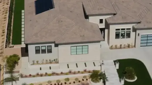 An aerial shot of a modern, one-story home with a desert landscape