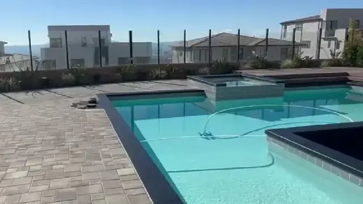 A modern, rectangular pool, sparkling in the sunshine
