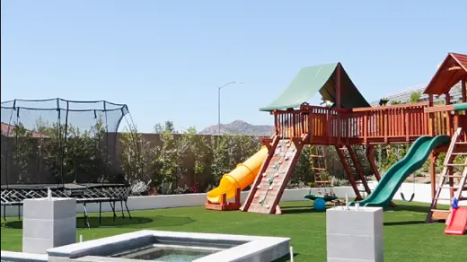 A vibrant backyard featuring a pool, playground, and trampoline