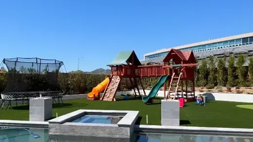 Backyard play area with trampoline, slide and pool
